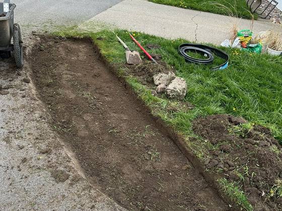 Bare soil along a driveway before a stone bed install in Akron, NY