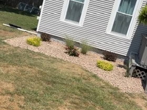 Stone bed wrapping the side of a home in Clarence, NY