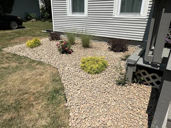 River rock bed running along a front walk in Akron, NY