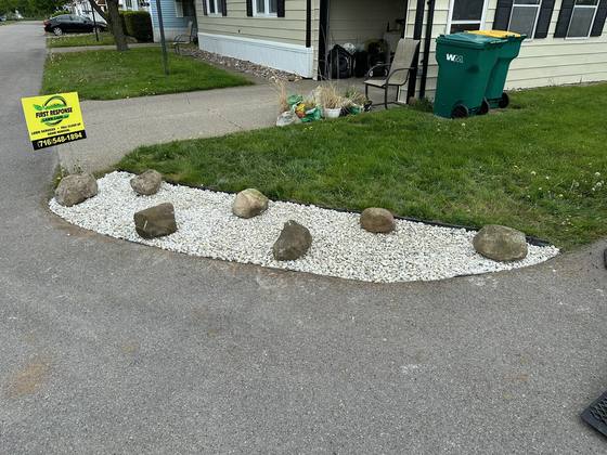 White stone bed with fieldstone boulders along a driveway in Akron, NY